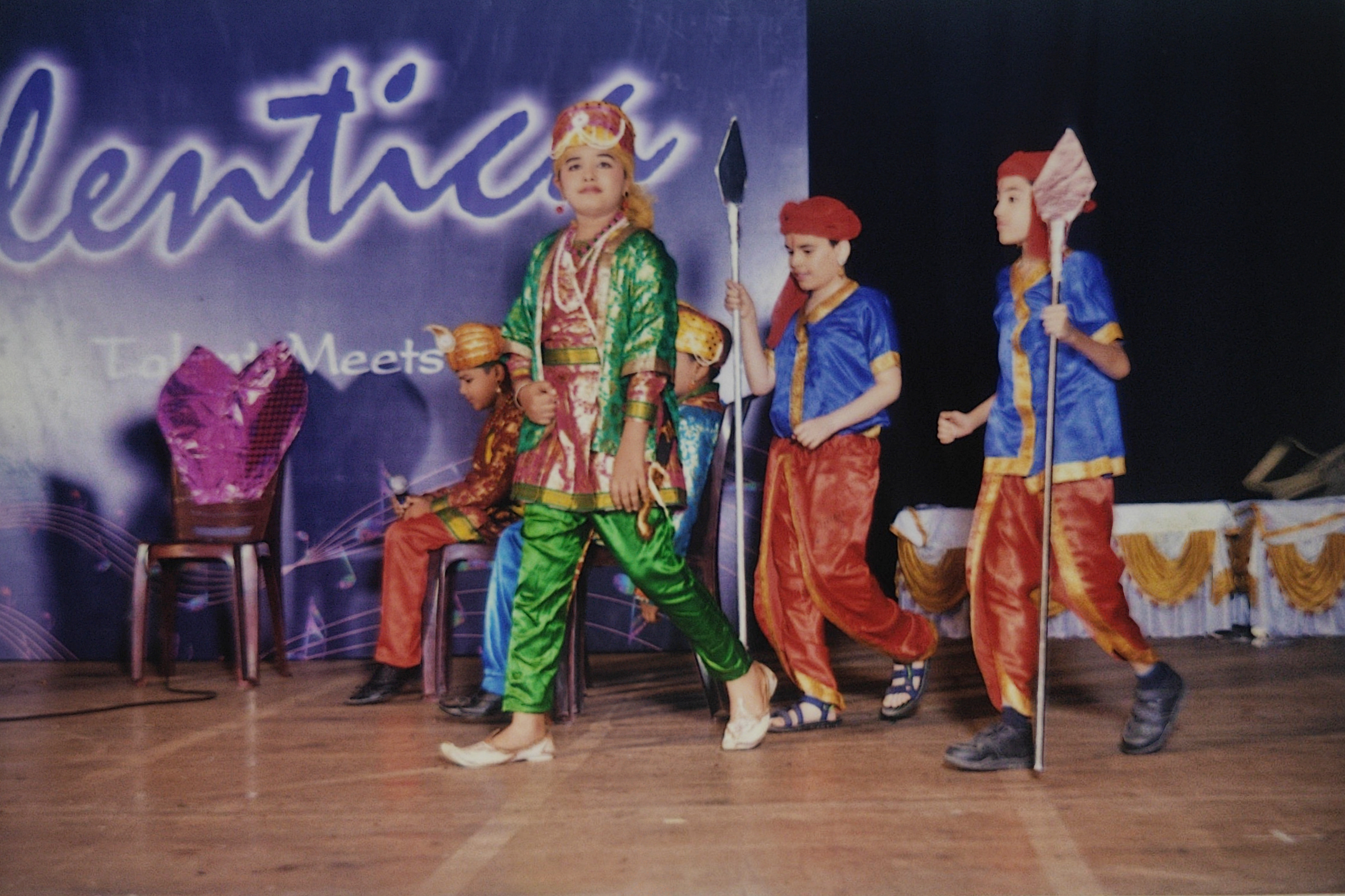 Emperor Akbar walking across the stage accompanied by royal guards.