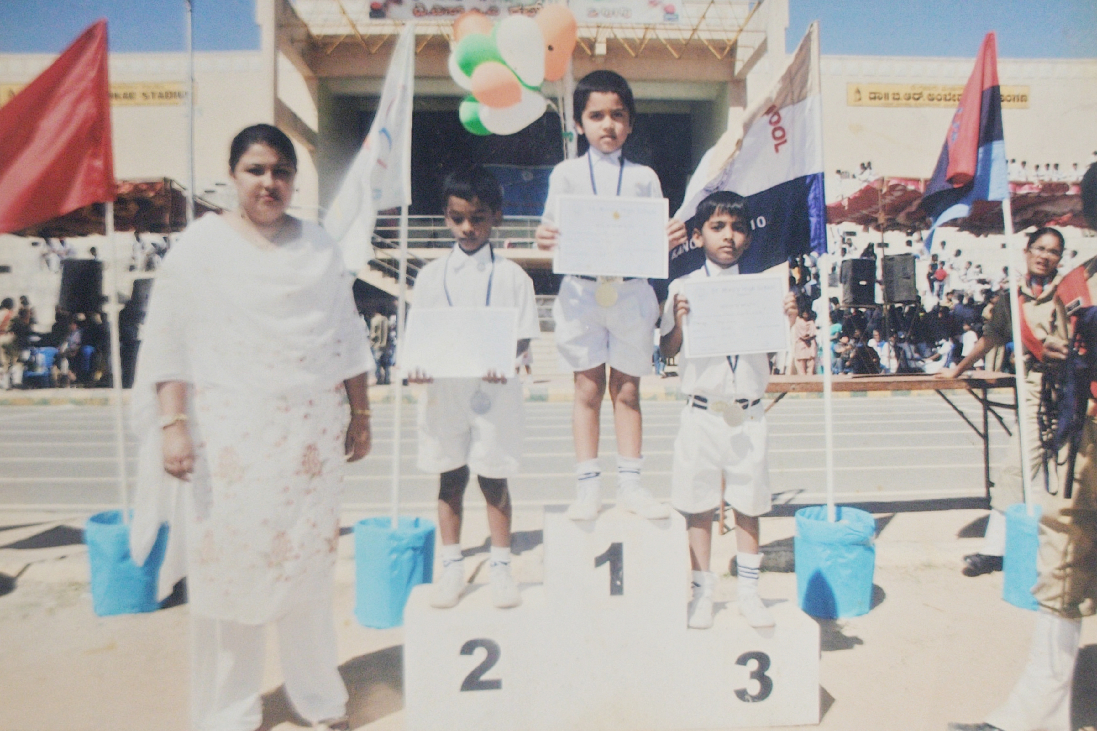 Standing on the #1 podium holding certificate and gold medal at St. Mira's athletics meet.